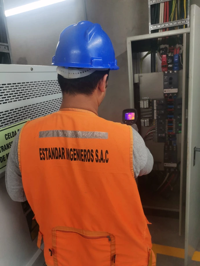 Técnico realizando termografía en tablero eléctrico industrial